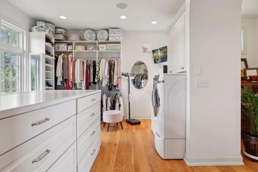 Walk-in primary closet featuring washer and dryer
