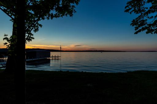 Twilight lake view with private dock silhouetted against sunset sky.
