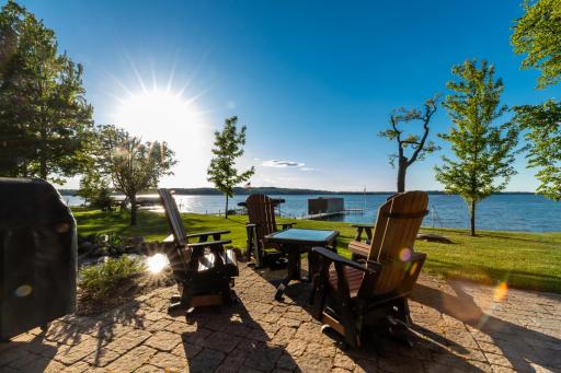 Peaceful lakeside patio with Adirondack seating and panoramic water views—perfect for sunrise coffee or evening relaxation.