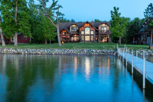 Twilight view of the home reflecting on calm lake waters.