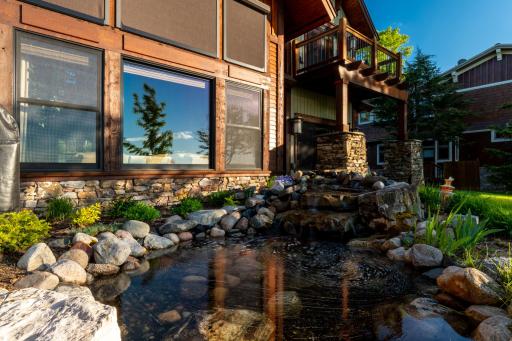 Backyard pond with natural stone edge and lush landscaping.