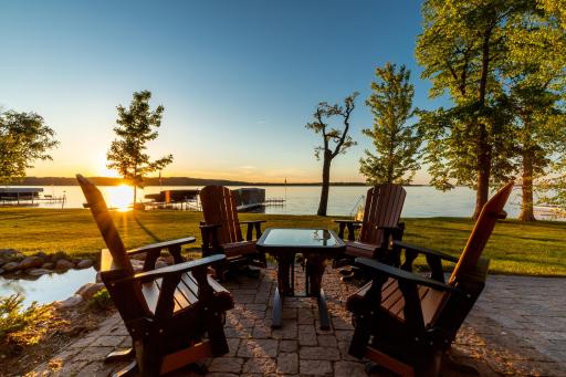 Lakeside firepit patio with panoramic sunset views and seating.