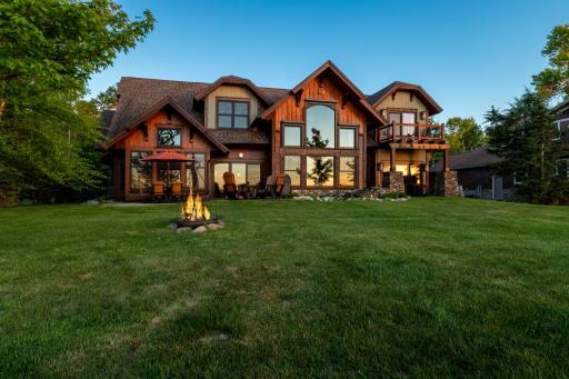Stunning lakeside retreat with dramatic sunset views, floor-to-ceiling windows, and cozy outdoor firepit.