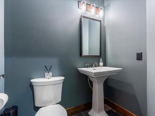 Modern powder room with pedestal sink, accent lighting, and designer paint tones.