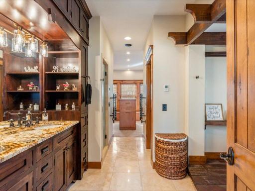 Dual vanity ensuite with custom cabinetry and access to private dressing area.