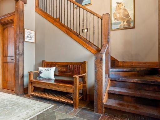 Rustic staircase with handcrafted wood railings and cozy built-in bench—full of lodge-style charm.