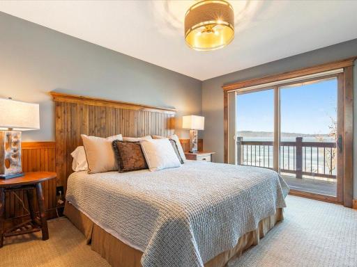 Guest bedroom with wood headboard, warm tones, and access to outdoor balcony.