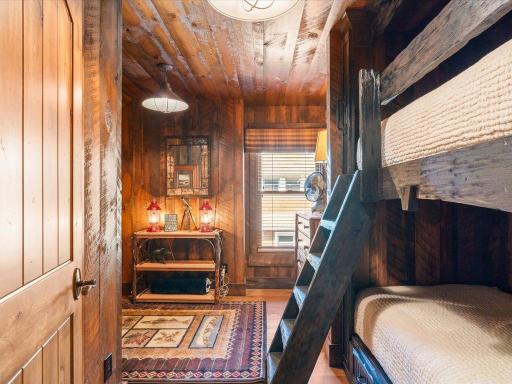 Cozy sleeping nook with log-style furniture, wood walls, and lakeside lodge character.