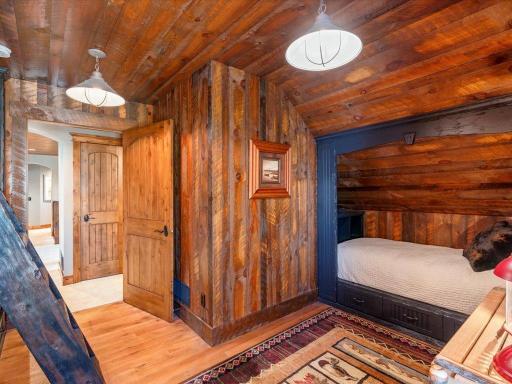 Hallway leading to rustic bunk beds and bedrooms, showcasing reclaimed wood details.