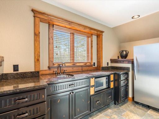 Custom vanity space with black cabinetry, granite counters, and built-in storage.