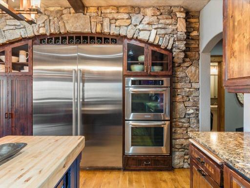 Premium stainless steel appliances framed by custom stonework and arched built-in cabinetry.