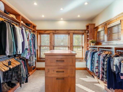 Expansive walk-in closet with custom built-ins, center island, and natural light.