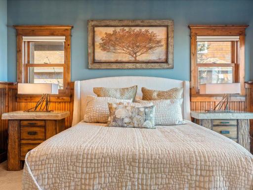 Primary bedroom with custom wood accents, neutral tones, and warm natural light.