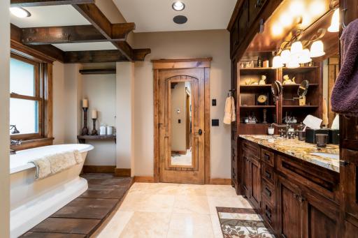 Spa-inspired ensuite with dual vanity, wood cabinetry, and walk-in shower.
