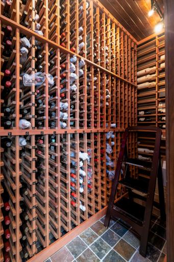 Expansive wine collection display with full-height custom racks and rich wood tones.