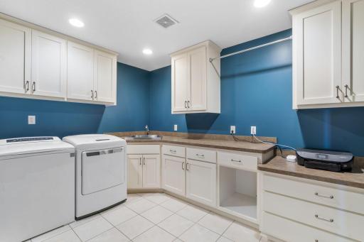 A large laundry room sits on the upper level with great cabinet and countertop space along with drying bars.