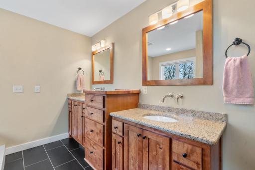 A spa like primary bath offers dual sinks, separate tub and shower and heated tile flooring.