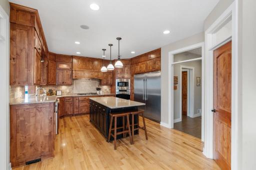 A chef's kitchen offers granite counter tops, high end stainless steel appliances and ample cabinet and counter space for meal prep.