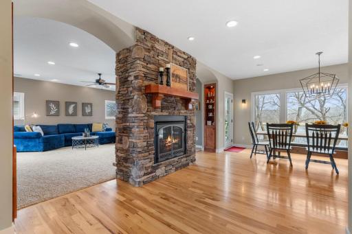 A statement dual sided fireplace sits as a focal point joining the dining space and main floor living room.