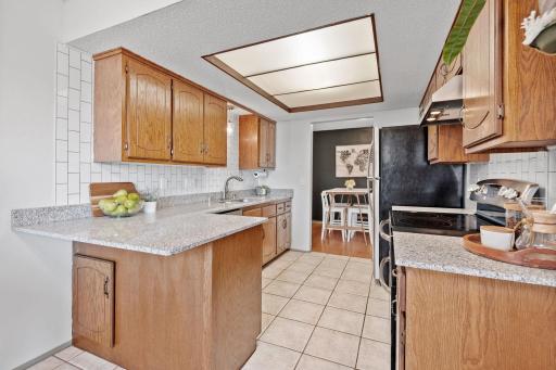 Updated kitchen includes beautiful wood cabinets, granite countertops, tile backsplash and stainless appliances.