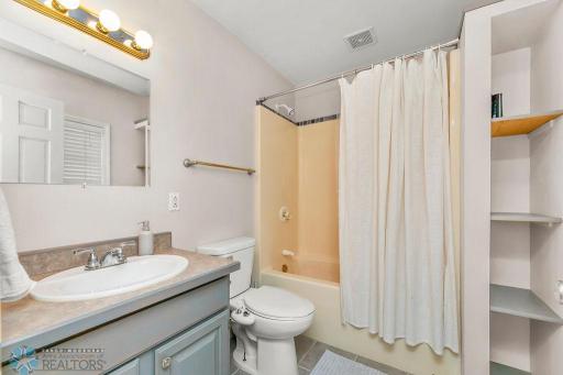 Full Bathroom. Spacious with built-in shelves for storage & window offers light.