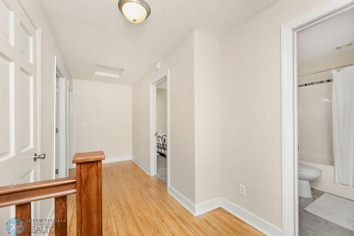 Upstairs hallway with original hardwood floors & hall closet