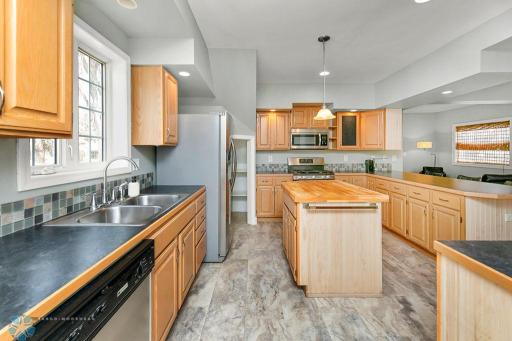 Kitchen w/ island, corner pantry, tile backsplash, wine fridge, stainless appliances incl. gas range.