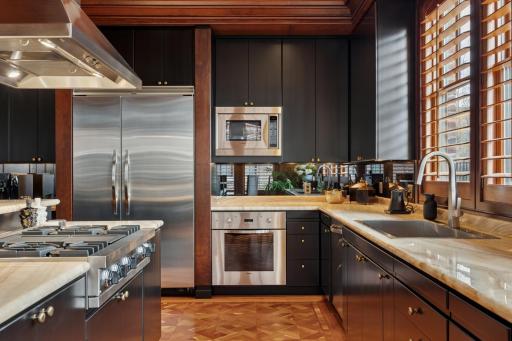 The kitchen is a showplace, featuring a dramatic backlit onyx worktop. The appliances and cabinetry are of the highest level.