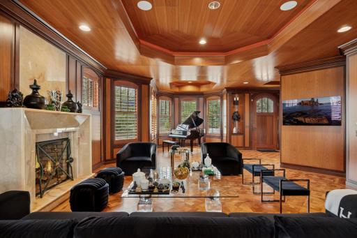 An open main level floor plan with hand-laid wood blockfloors, custom woodwork, and fireplace with onyx surrounding.