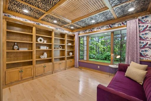 Tucked away on the main level, the office offers a polished, distraction-free workspace with built-in bookshelves, statement wallpaper, and custom ceiling details.