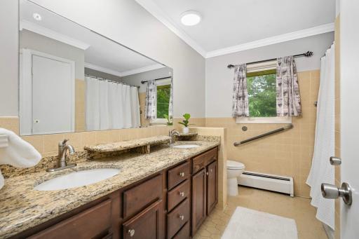 Full bathroom with granite countertop and double undermount sinks.