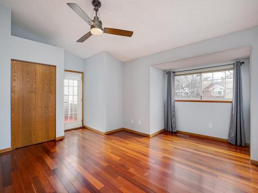 The spacious primary bedroom, with vaulted ceilings and access to the private balcony.