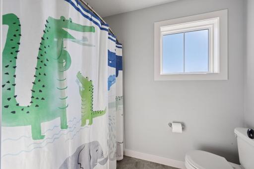 The shower and toilet area is separate from the sinks.