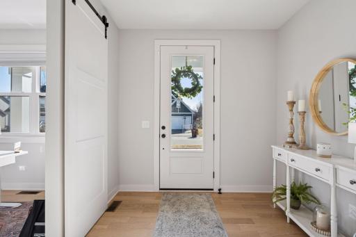 A generously sized foyer greets you as you enter the home, featuring beautiful wood floors, a picture window door that brings in natural light, and a sense of warmth and openness.
