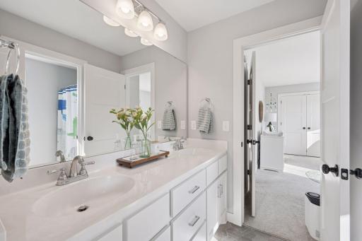 Jack and Jill bath offers double sink with mirror, wall lights, LVP flooring and full tub/shower.