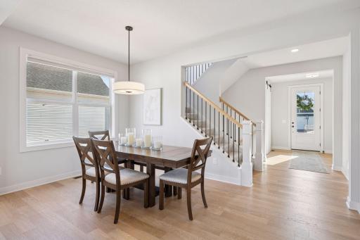 The formal dining space is accented by an charming chandelier, beautiful wood flooring, and offers ample room for entertaining guests in style.