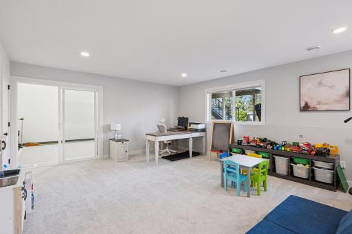 The game room offers a double window, recessed lighting and plenty of space. Access to the sport court through the sliding door.