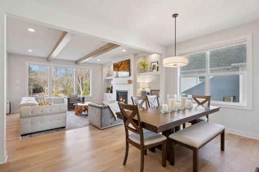 The formal dining space flows seamlessly into the living room, where exposed beams add character and a sense of openness.