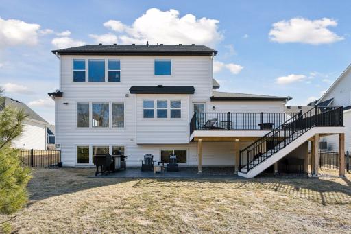 A generous, fully fenced in backyard offers plenty of entertaining space with a stamp concrete patio at the base of the oversized deck.