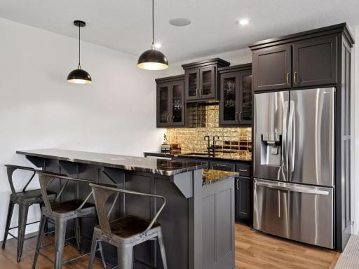 Enjoy the lower-level wet bar with custom backsplash tile.