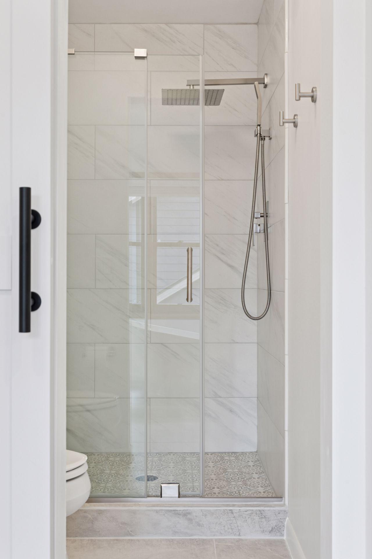 Water Closet and Rain Shower with Frameless Glass Shower Door