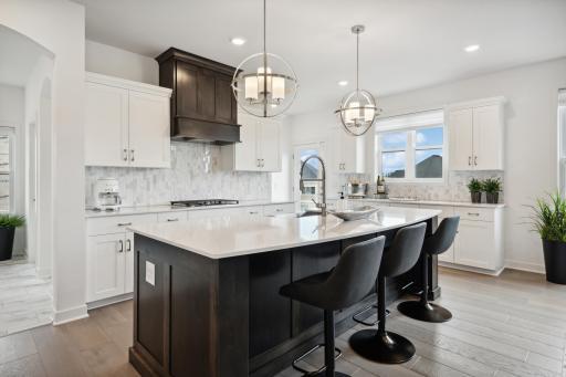 (Photo of model home, finishes will vary) This chef-ready kitchen is graced with a quartz center island ideal for casual dining and entertaining, complemented by extensive cabinetry room and high-end stainless steel appliances to inspire new recipes.