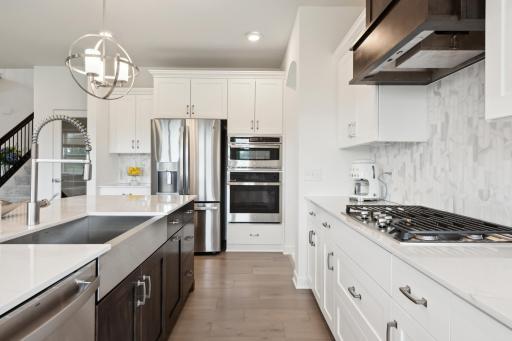 (Photo of model home, finishes will vary) Thanks to the home’s spacious, free-flowing layout, residents and guests can migrate from drinks at the center island to dinner and entertainment
