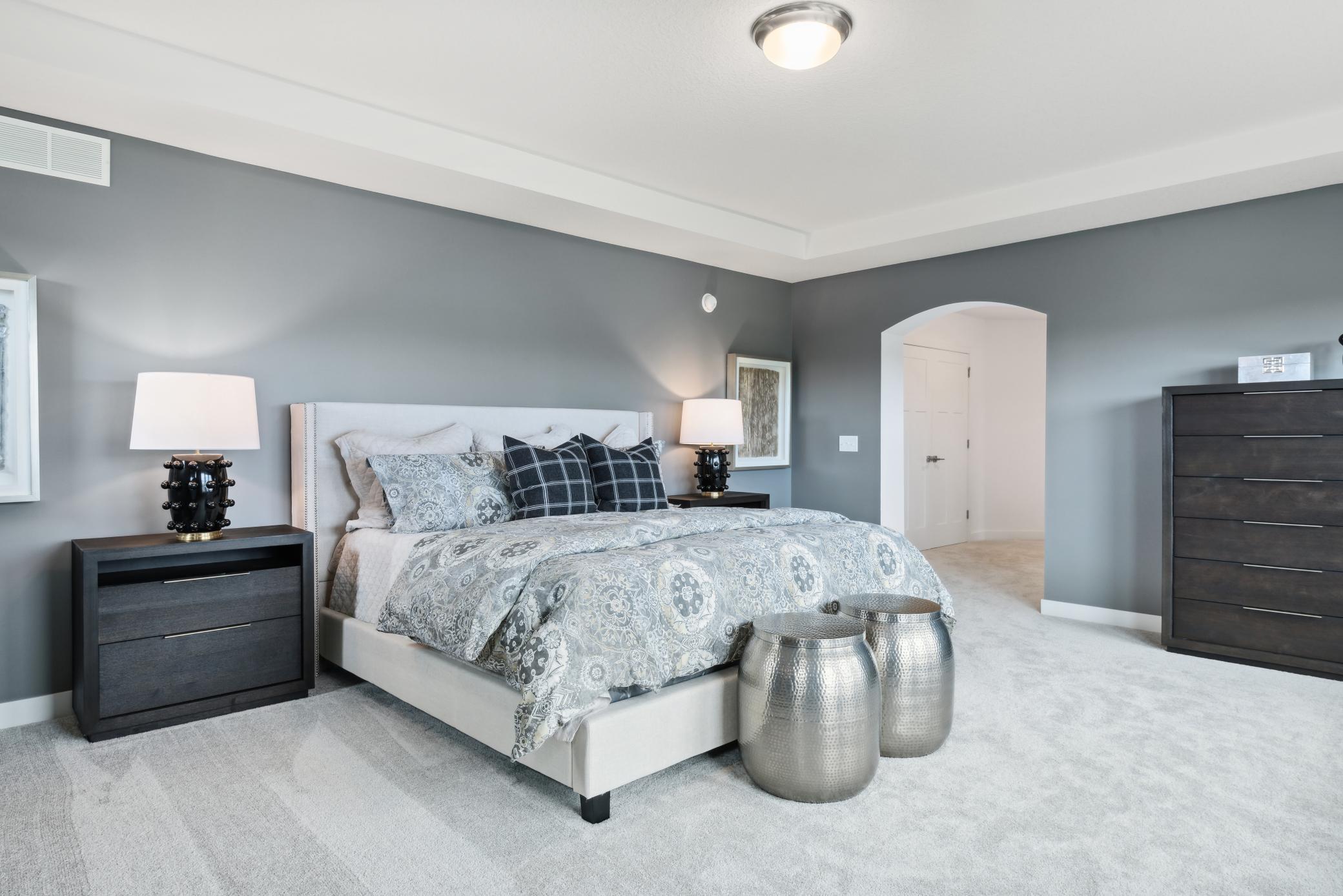 (Photo of model home, finishes will vary) The ultimate getaway, the owner’s suite boasts a sprawling bedroom with an elegant tray ceiling to create a serene atmosphere, complemented by a spa-style bathroom with a soaking tub for added luxury.