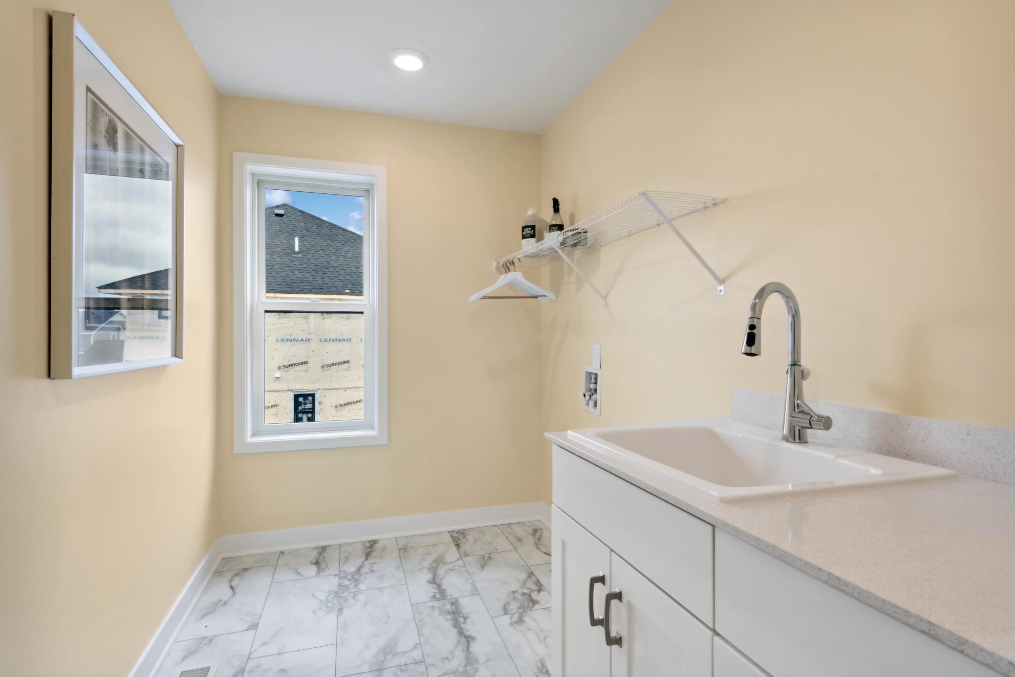 (Photo of model home, finishes will vary). Situated on the second floor with all the bedrooms is a large laundry room to get chores finished. It features a convenient sink, mesh-wire shelving and electric hook-ups for a new washer and dryer.