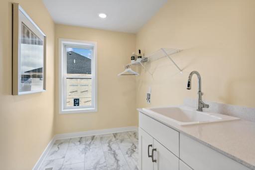 (Photo of model home, finishes will vary). Situated on the second floor with all the bedrooms is a large laundry room to get chores finished. It features a convenient sink, mesh-wire shelving and electric hook-ups for a new washer and dryer.