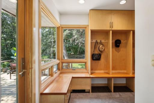 The mudroom is functional and attractive, with storage cubbies, cabinets and benches. Easy access to the deck for summer dining!