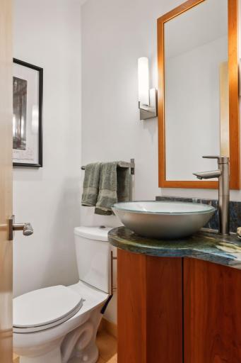 The guest half bath is highlighted with a vanity with basin sink.