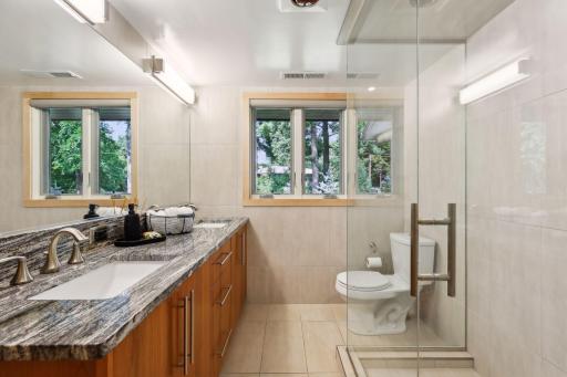 The bedrooms share an updated contemporary three-quarter bath, featuring a vanity with dual sinks, and a large step-in shower.
