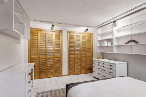 A second potential bedroom or home office features ceramic tiled flooring, lovely built-in shelving, and two double closets.